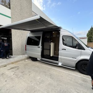 Mobile installation van with awning for outdoor setup at Cube World USA.