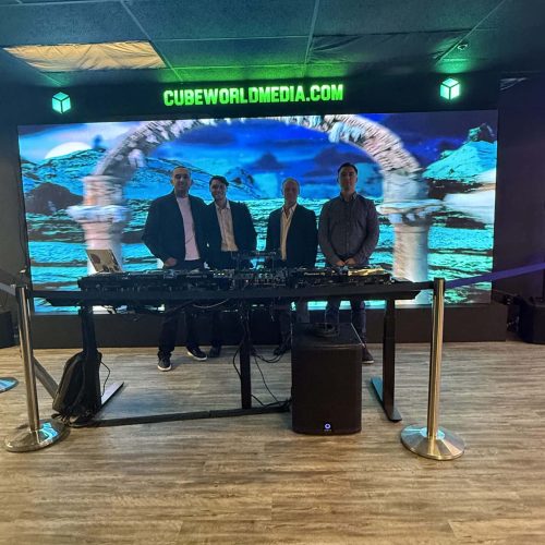 Group of four professionals at Cube World USA booth during a corporate event.