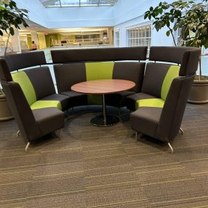 Office lounge seating with curved design and colorful cushions.