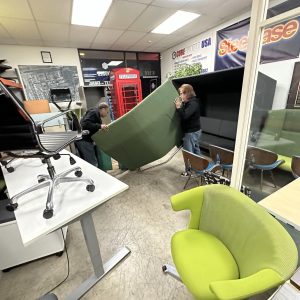 Office furniture being installed at Cube World USA during a commercial setup.