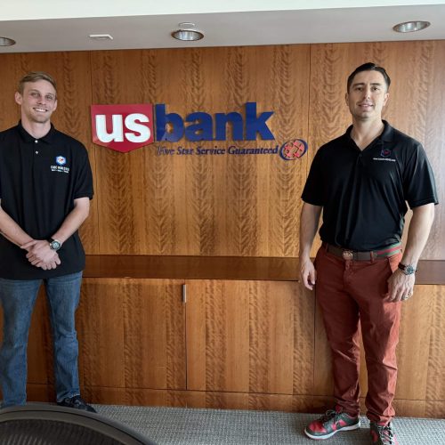 Two commercial brokers standing in front of US Bank logo at Cube World USA.