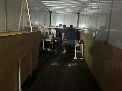 Workers unloading office furniture during liquidation sale at Cube World USA.