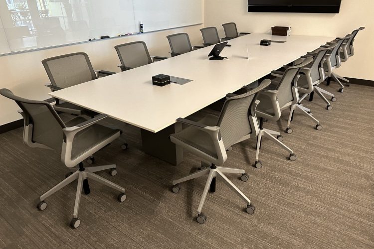 Conference room setup with ergonomic chairs and a large table for meetings.