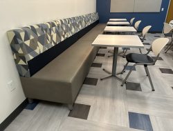 Office break area with seating and tables for employee relaxation.