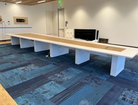 Modern office furniture liquidation table in a clean, well-lit conference room.