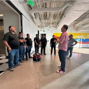 Group of people receiving installation training in a modern indoor space.
