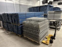 Relocation of industrial shelving and metal racks at Cube World USA during office move.