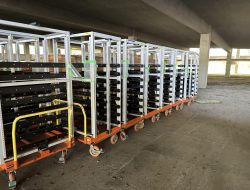 Industrial storage racks on carts under a bridge for office move.