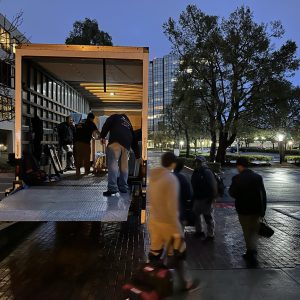 Shipping container with people loading and unloading goods.