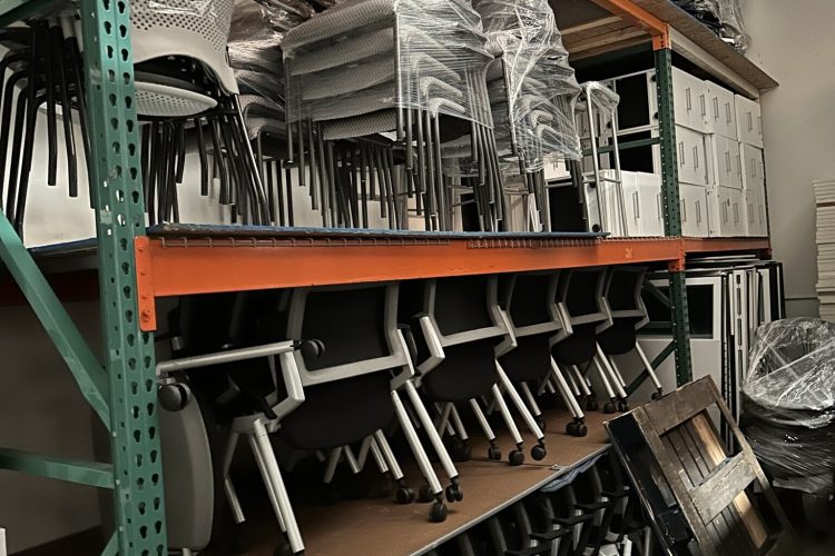 Office chairs stacked on shelves for storage and organization.