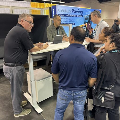 Business professionals networking at Cube World USA booth during industry event.