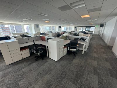 Office furniture liquidation with modern desks and workstations in a spacious, well-lit office envir.