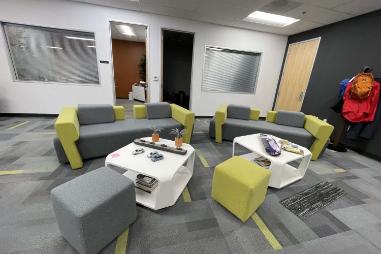 Modern office lounge with colorful seating and contemporary design elements.