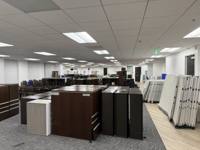 Modern office furniture display with desks, cabinets, and partitions for rent.