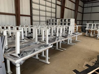 Office desks and tables stacked for liquidation sale at Cube World USA.