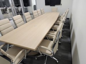 Conference room table with beige chairs for professional office meetings.