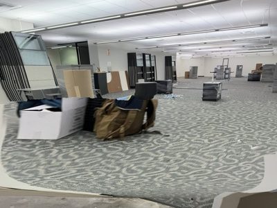Office furniture liquidation with desks, shelves, and chairs in a spacious showroom.