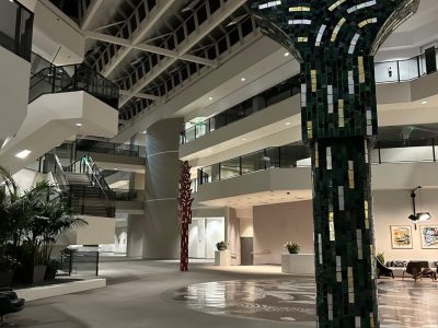 Modern office lobby with artistic mosaic pillar and spacious design.